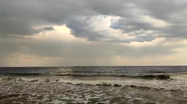 Denizde yağmur. Yağmurun görüntüsü, yağmur bulutları, beyaz köpüklü deniz ve deniz dalgaları. Hava bulutlu. Deniz Burnu. Deniz manzarası. Doğa. Doğal arkaplan