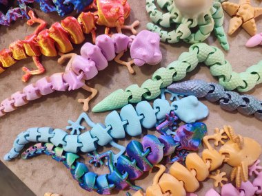 Erimiş plastikten üç boyutlu yazıcıya basılmış yaratıcı çok renkli modeller. 3 boyutlu yazıcı tarafından yaratılmış farklı renkte farklı oyuncak nesneleri. Konsept 3 boyutlu baskı. Yeni 3D Yazdırma Katkı Teknolojisi