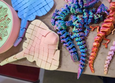 Erimiş plastikten üç boyutlu yazıcıya basılmış yaratıcı çok renkli modeller. 3 boyutlu yazıcı tarafından yaratılmış farklı renkte farklı oyuncak nesneleri. Konsept 3 boyutlu baskı. Yeni 3D Yazdırma Katkı Teknolojisi