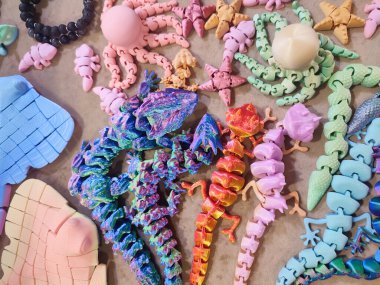 Erimiş plastikten üç boyutlu yazıcıya basılmış yaratıcı çok renkli modeller. 3 boyutlu yazıcı tarafından yaratılmış farklı renkte farklı oyuncak nesneleri. Konsept 3 boyutlu baskı. Yeni 3D Yazdırma Katkı Teknolojisi