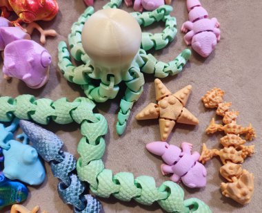 Erimiş plastikten üç boyutlu yazıcıya basılmış yaratıcı çok renkli modeller. 3 boyutlu yazıcı tarafından yaratılmış farklı renkte farklı oyuncak nesneleri. Konsept 3 boyutlu baskı. Yeni 3D Yazdırma Katkı Teknolojisi
