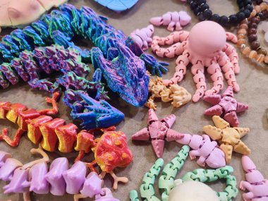 Erimiş plastikten üç boyutlu yazıcıya basılmış yaratıcı çok renkli modeller. 3 boyutlu yazıcı tarafından yaratılmış farklı renkte farklı oyuncak nesneleri. Konsept 3 boyutlu baskı. Yeni 3D Yazdırma Katkı Teknolojisi