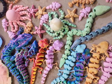 Erimiş plastikten üç boyutlu yazıcıya basılmış yaratıcı çok renkli modeller. 3 boyutlu yazıcı tarafından yaratılmış farklı renkte farklı oyuncak nesneleri. Konsept 3 boyutlu baskı. Yeni 3D Yazdırma Katkı Teknolojisi