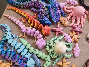 Erimiş plastikten üç boyutlu yazıcıya basılmış yaratıcı çok renkli modeller. 3 boyutlu yazıcı tarafından yaratılmış farklı renkte farklı oyuncak nesneleri. Konsept 3 boyutlu baskı. Yeni 3D Yazdırma Katkı Teknolojisi