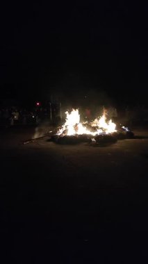 Maslenitsa tatili sırasında sokakta büyük kamış heykelciği yakmak. Putperest ayini. Etrafı izleyen bir sürü insan var. Dışarıda şenlik var. Dikey