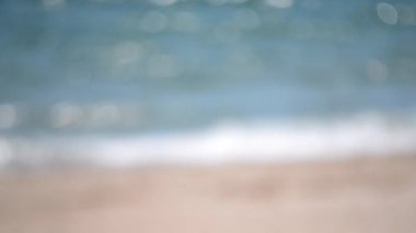 Deniz. Beyaz köpüklü mavi deniz dalgaları gün içinde sarı kumsalda yuvarlanıyor. Deniz kıyısındaki kumlu sahilde deniz dalgaları. Deniz kıyısında. Deniz kıyısında. Arka plan bulanık. Doğa. Hiç kimse. Doğal soyut arkaplan