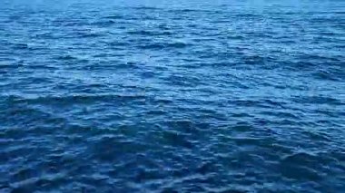 Deniz manzaralı. Sakin rüzgarsız havada mavi deniz manzarası. Deniz suyunun yüzeyinde küçük dalgalar ve dalgalar. Deniz Burnu. Hiç kimse. Doğa arkaplanı. Doğal arkaplan.