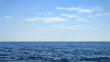 Deniz manzaralı. Deniz Burnu. Deniz manzarası. Deniz manzarası. Mavi deniz yüzeyi, mavi gökyüzü, ufuk çizgisi ve beyaz bulutlar. Sakin rüzgarsız hava. Hiç kimse. Doğa arkaplanı. Doğal arkaplan.