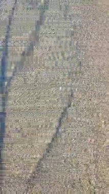 Güneşli bir günde, deniz kıyısının kumlu sahilinde güzel, şeffaf, küçük deniz dalgaları. Temiz su, güneş parlaması ve yakın plan kumlu zeminde gölgeler. Doğal soyut arka plan. Dikey