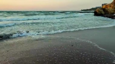 Gün batımında ve şafakta denizde beyaz köpüklü büyük dalgalar. Fırtına. Mavi deniz, kızıl gökyüzü. Fırtınalı deniz. Kıyı sahili kıyısı. Deniz kıyısı kıyısı. Doğal arka plan doğa fırtınası
