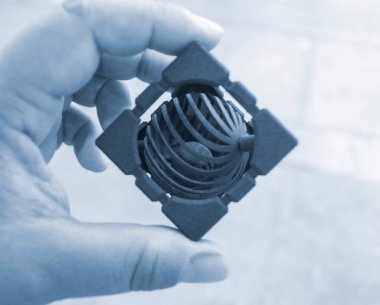 Tozdan 3D yazıcıya basılmış el plastiği modelleri tutan kişi. Polyamide tozundan 3 boyutlu yazıcıda nesneler oluşturuldu. Yeni 3D baskı teknolojisi. Modern 3 boyutlu katkı teknolojileri. MJF