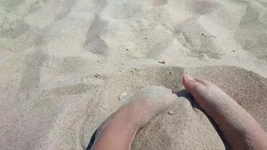 Kumsalda kumdan hoşlanan biri. Güneşli bir yaz gününde kumsalda çıplak ayak gömen beyaz tenli bir adam. Tatil tatili tatil tatili dinlenme turizmi dokunuşunu kabul edin
