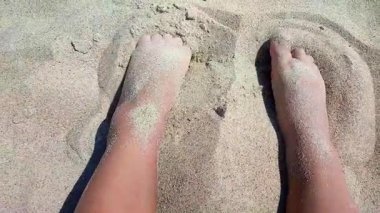 Kumsalda kumdan hoşlanan biri. Güneşli bir yaz gününde kumsalda çıplak ayak gömen beyaz tenli bir adam. Tatil tatili tatil tatili dinlenme turizmi dokunuşunu kabul edin