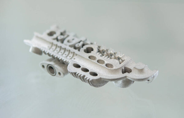 Металлический объект, отпечатанный на 3D принтере из металлического порошка. Модель, созданная на 3D принтере из металлического порошка. Технология Metal Jet. Новые современные технологии 3D-печати. Аддитивная прогрессивная технология. Концепция
