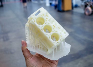 Avucunun içinde erimiş beyaz plastikten 3 boyutlu yazıcıya basılmış araba motoru prototipi tutan kişi. Üç boyutlu model. Modern yeni baskı endüstrisi. Katkı sağlayan yenilikçi modelleme teknolojisi.