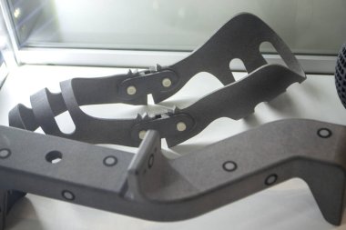 Plastik poliyamid tozundan üç boyutlu yazıcıya basılmış farklı modeller. Bacağı iyileştirmek için ortoz bandajı çerçevesi. Dizi plastikten. 3D yazıcı tozu teknolojisi, MJF MJF Met Füzyon teknolojisi.