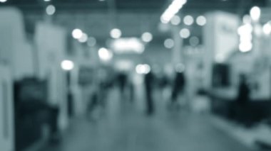 Binada yürüyen insanlar. Duvarları, zemini, tavan lambaları olan bir bina. İçerideki insanların siluetleri. Bir sürü insan yürüyor. Erkekler ve kadınlar uzun salonda. Sergi merkezi. Bulanık arkaplan