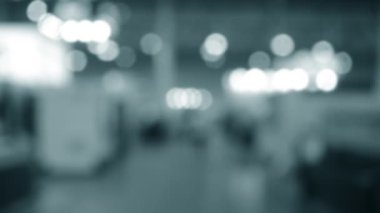 Binada yürüyen insanlar. Duvarları, zemini, tavan lambaları olan bir bina. İçerideki insanların siluetleri. Bir sürü insan yürüyor. Erkekler ve kadınlar uzun salonda. Sergi merkezi. Bulanık arkaplan