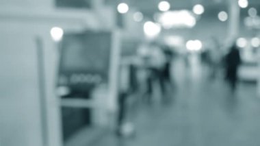 Binaya makineler ve kontrol panelleri olan ekipmanlarla giren insanlar. Duvarları, zemini, tavan lambaları olan bir bina. İçerideki insanların siluetleri. Mavi renk. Bulanık arkaplan.