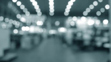 Binada yürüyen insanlar. Duvarları, zemini, tavan lambaları olan bir bina. İçerideki insanların siluetleri. Bir sürü insan yürüyor. Erkekler ve kadınlar uzun salonda. Sergi merkezi. Bulanık arkaplan