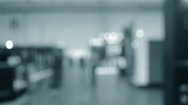 Binada yürüyen insanlar. Duvarları, zemini, tavan lambaları olan bir bina. İçerideki insanların siluetleri. Bir sürü insan yürüyor. Erkekler ve kadınlar uzun salonda. Sergi merkezi. Bulanık arkaplan