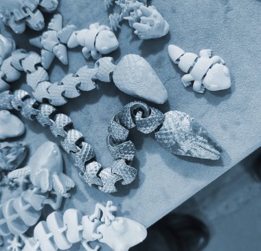Üç boyutlu yazıcıya basılmış sanat eserleri. Erimiş plastikten üç boyutlu bir yazıcıda yaratılmış çeşitli yaratıcı modeller. Konsept 3 boyutlu baskı. Yeni modern 3D baskı katkı teknolojisi. Mavi renk