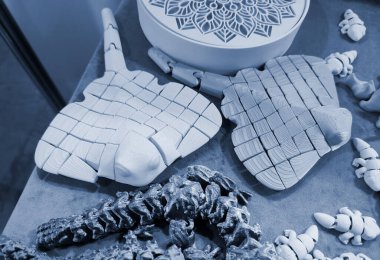 Üç boyutlu yazıcıya basılmış sanat eserleri. Erimiş plastikten üç boyutlu bir yazıcıda yaratılmış çeşitli yaratıcı modeller. Konsept 3 boyutlu baskı. Yeni modern 3D baskı katkı teknolojisi. Mavi renk