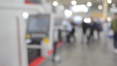 Binaya makineler ve kontrol panelleri olan ekipmanlarla giren insanlar. Duvarları, zemini, tavan lambaları olan bir bina. İçerideki insanların siluetleri. Mavi renk. Bulanık arkaplan.