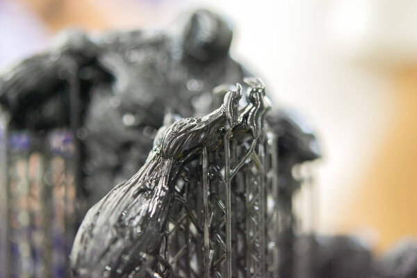 An object printed on a 3D printer from hardened rubber close-up. Model black color created on a 3D printer from hardened rubber under influence of ultraviolet light. SLA 3D printing. Stereolithography