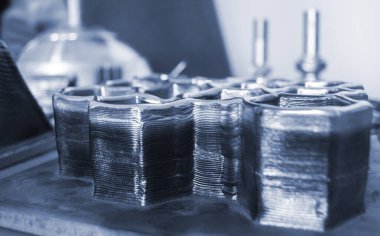 Masadaki erimiş metal filamanından üç boyutlu yazıcıya basılmış nesneler. Metalden 3D yazıcı tarafından basılan nesne. Katkı maddesi üretim çözeltisi. Eriyen metal ipliğinden 3D yazıcıda nesne oluşturuldu