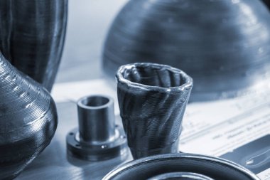 Masadaki erimiş metal filamanından üç boyutlu yazıcıya basılmış nesneler. Metalden 3D yazıcı tarafından basılan nesne. Katkı maddesi üretim çözeltisi. Eriyen metal ipliğinden 3D yazıcıda nesne oluşturuldu