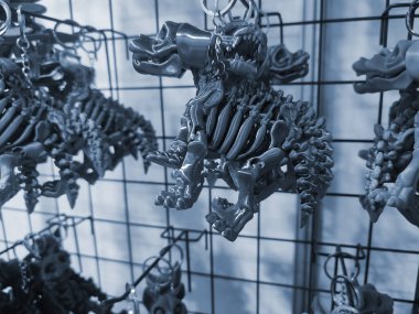 Zincirli erimiş plastikten 3 boyutlu yazıcıya basılmış köpek iskeleti şeklinde anahtarlıklar. Konsept 3 boyutlu baskı. Modern 3D baskı katkı teknolojisi. Mavi renk
