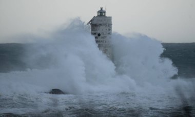 the lighthouse of the mangiabarche in calasetta, in southern sardinia, submerged by the waves of the stormy sea