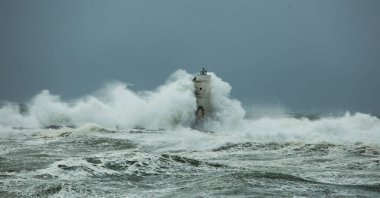 the lighthouse of the mangiabarche in calasetta, in southern sardinia, submerged by the waves of the stormy sea