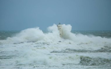 the lighthouse of the mangiabarche in calasetta, in southern sardinia, submerged by the waves of the stormy sea