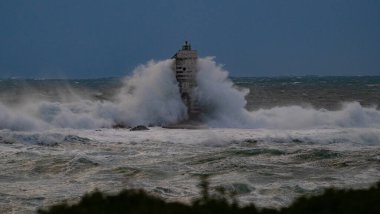 the lighthouse of the mangiabarche in calasetta, in southern sardinia, submerged by the waves of the stormy sea