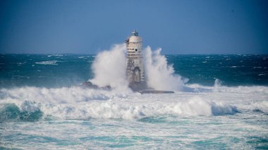 the lighthouse of the mangiabarche in calasetta, in southern sardinia, submerged by the waves of the stormy sea