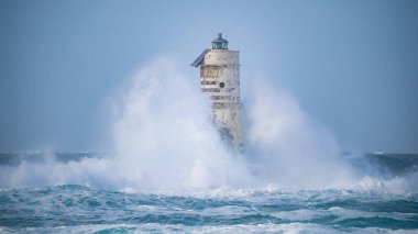 the lighthouse of the mangiabarche in calasetta, in southern sardinia, submerged by the waves of the stormy sea