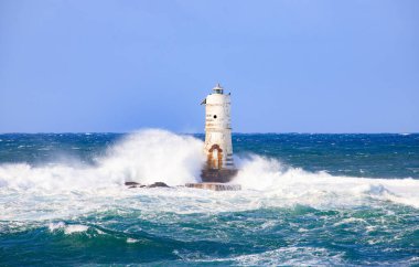 the lighthouse of the mangiabarche in calasetta, in southern sardinia, submerged by the waves of the stormy sea