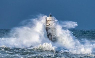 the lighthouse of the mangiabarche in calasetta, in southern sardinia, submerged by the waves of the stormy sea