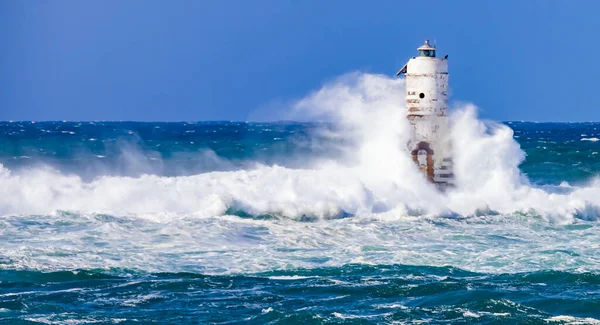 the lighthouse of the mangiabarche in calasetta, in southern sardinia, submerged by the waves of the stormy sea