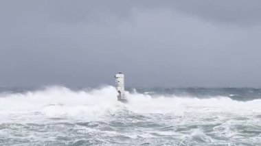 the lighthouse of the mangiabarche in calasetta, in southern sardinia, submerged by the waves of the stormy sea