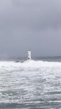 the lighthouse of the mangiabarche in calasetta, in southern sardinia, submerged by the waves of the stormy sea