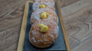 Homemade fried donuts filled with custard and seasoned with a veil of sugar