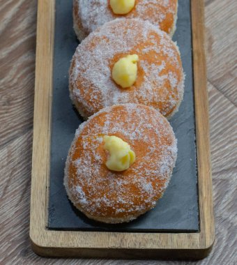 Homemade fried donuts filled with custard and seasoned with a veil of sugar