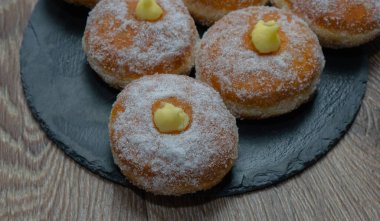 Homemade fried donuts filled with custard and seasoned with a veil of sugar