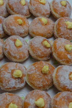 Homemade fried donuts filled with custard and seasoned with a veil of sugar