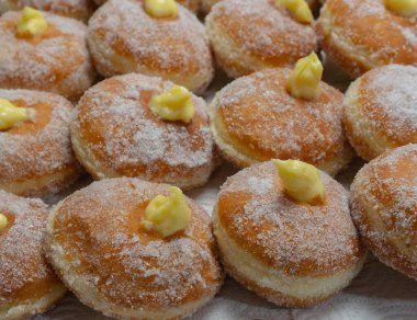 Homemade fried donuts filled with custard and seasoned with a veil of sugar