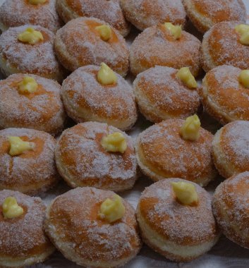 Homemade fried donuts filled with custard and seasoned with a veil of sugar