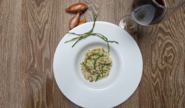 Beyaz tabakta kuşkonmaz, kuşkonmaz acutifolius ve risotto.